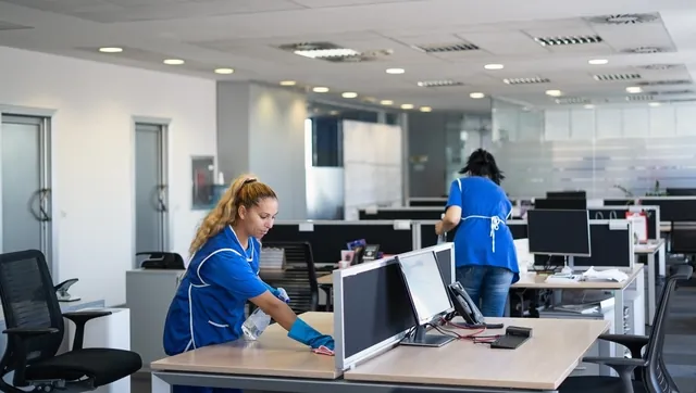 Cleaners wiping an office conference table