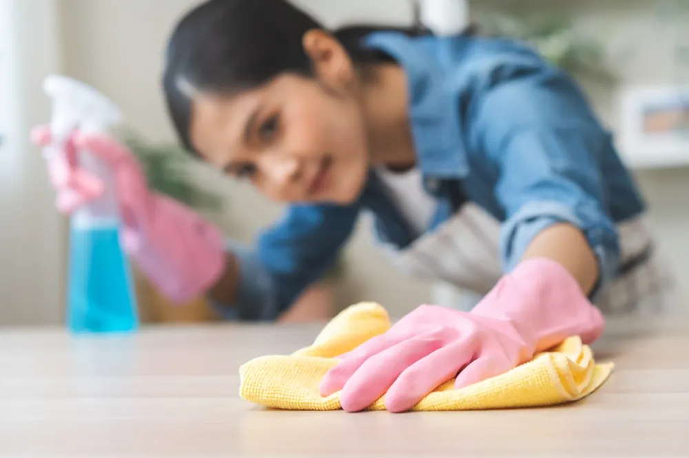 Gloved hands wiping a kitchen counter